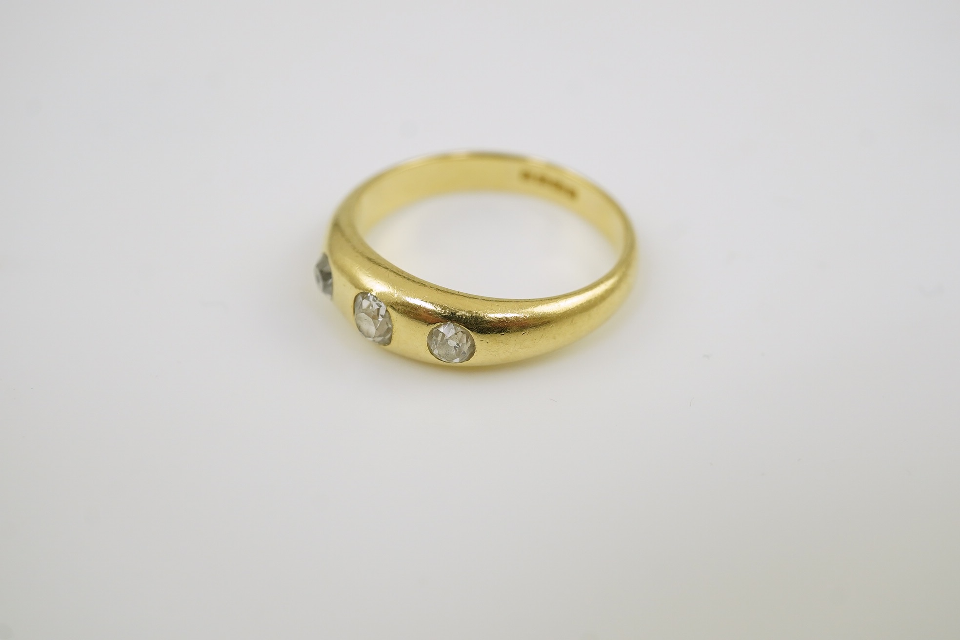 A George V 18ct gold and three stone gypsy set diamond ring